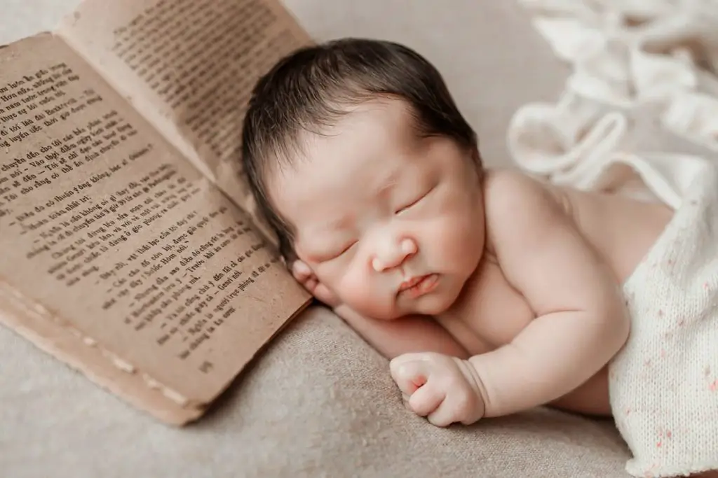 New born baby photoshoot sleeping with book