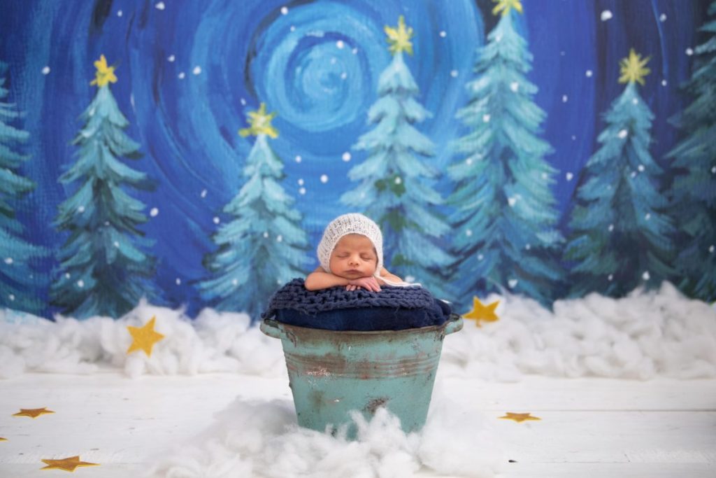 Baby photoshoot in blue bucket with snow covered and christmas background