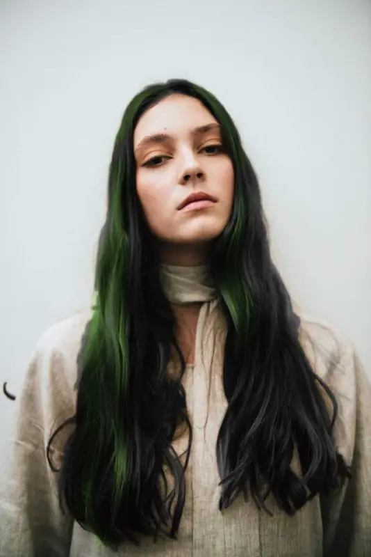 image of women with long black hair and green colored streaks